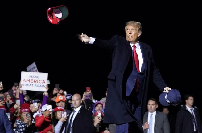Donald Trump rzuca czapkami w tłumu po swoim przemówieniu na wiecu wyborczym na Duluth International Airport w stanie Minnesota. 30.09.2020 r., fot. East News